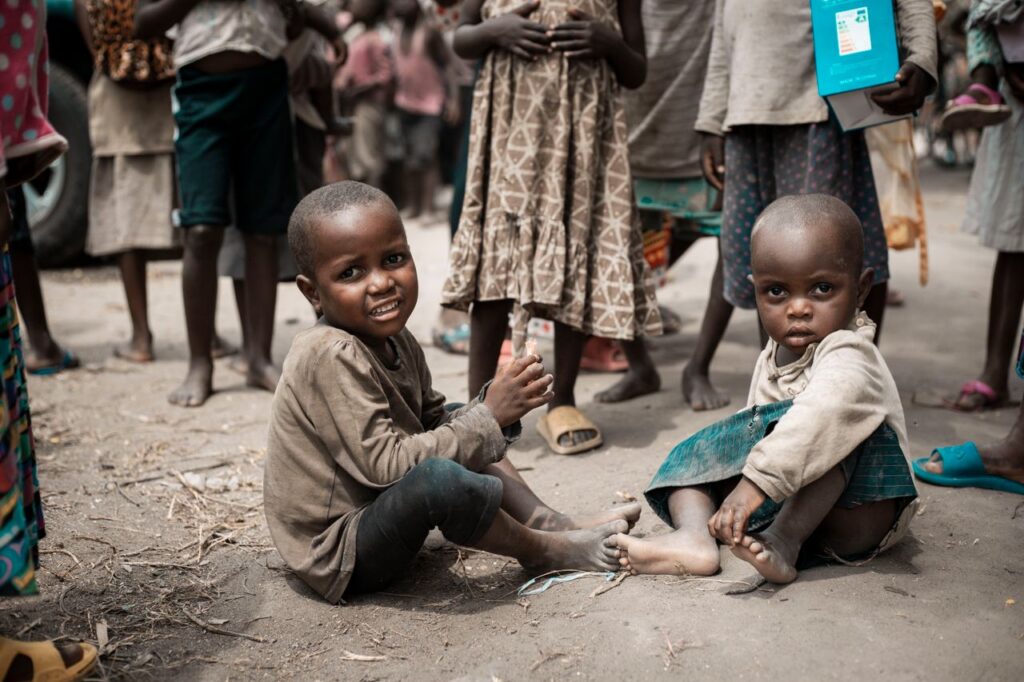 Smiling children sitting in a community setting, capturing the essence of childhood joy.