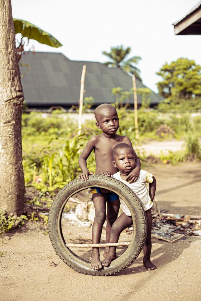 about-03 Two young boys playing with a tire in a village setting, Abia, Nigeria.