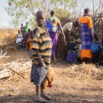 A vibrant scene of daily life in an African village with traditional attire.