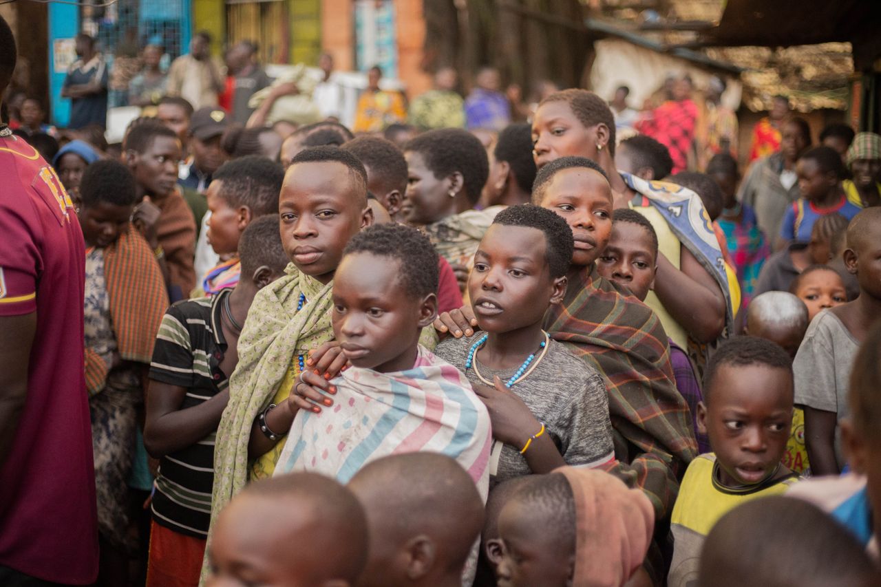 A vibrant street scene showcasing African children in traditional attire at a busy marketplace.